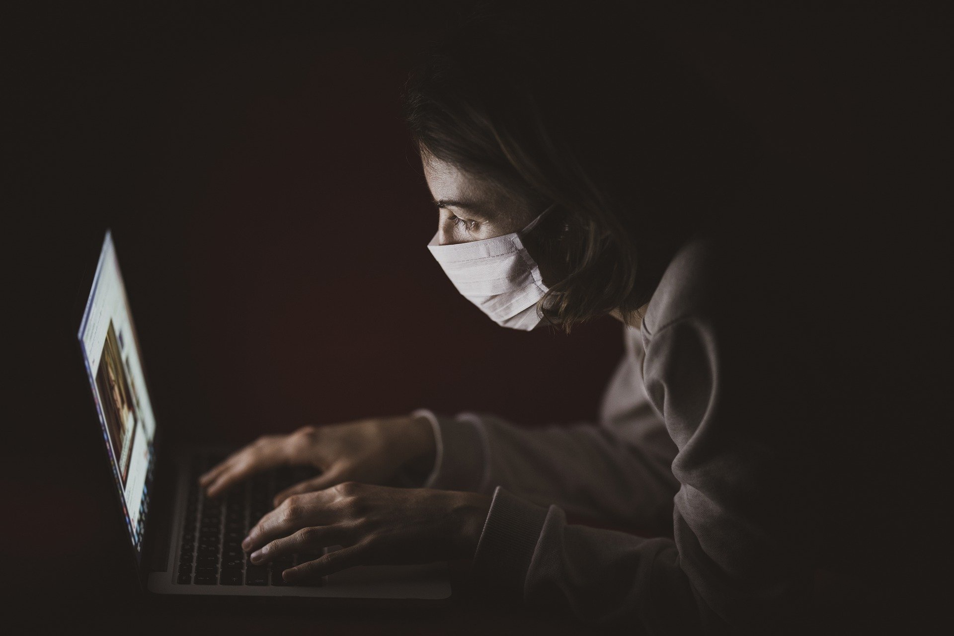 person with mask at computer